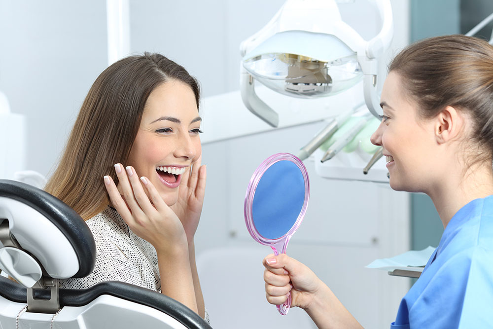 Lady smiling looking at teeth in mirror image